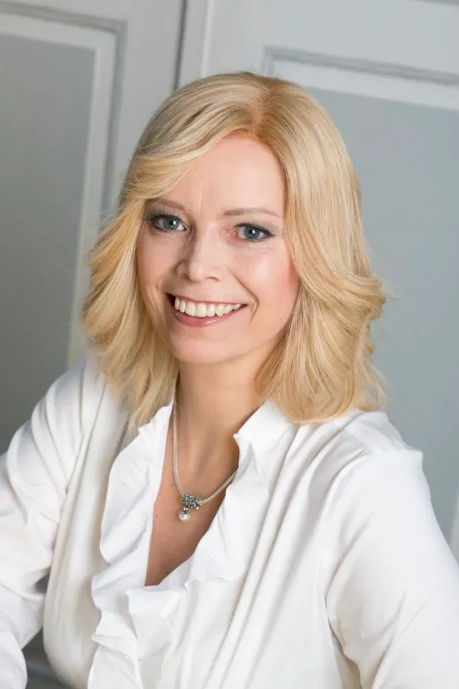 Trägerin mit blondem, schulterlangem Zweithaar, frontal