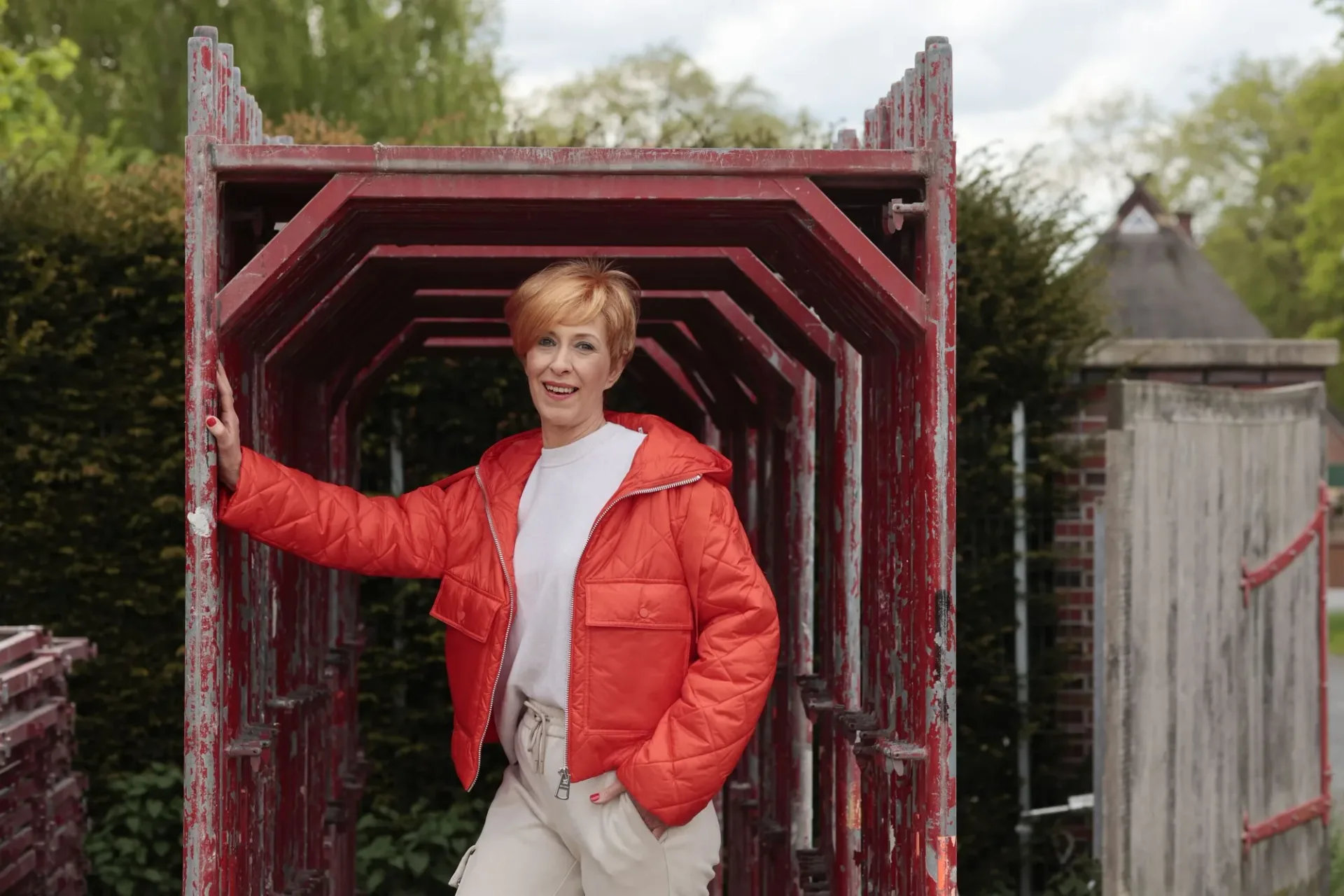 Trägerin mit kurzem Zweithaar draußen unterwegs, lachend